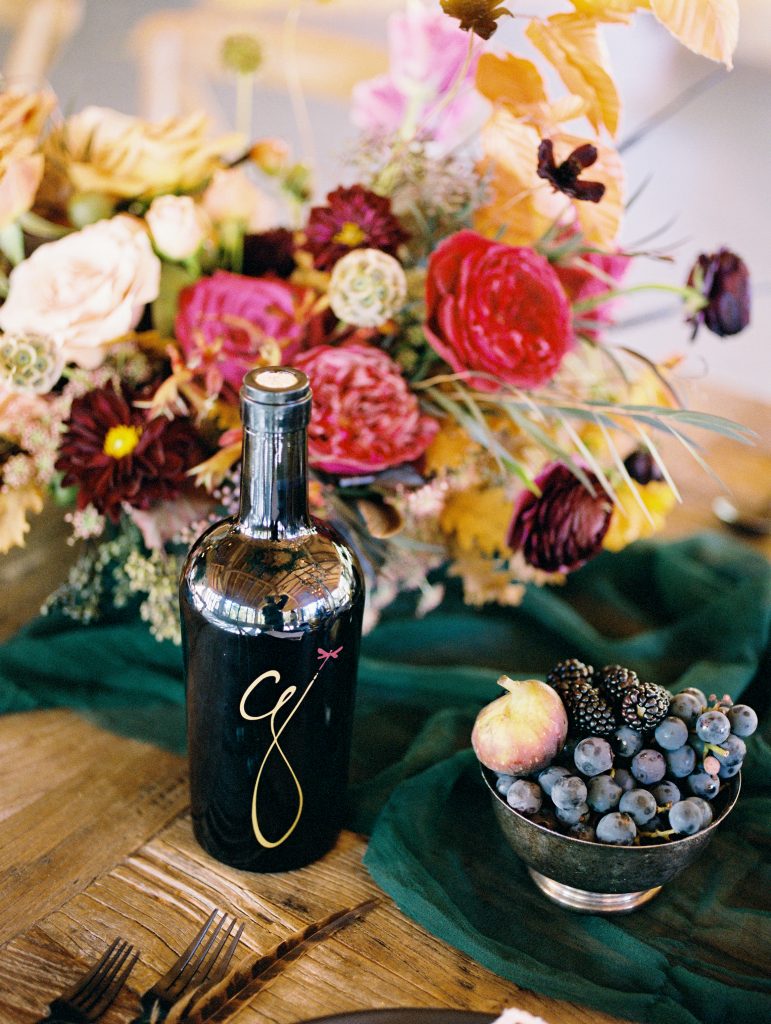 Photo of a bottle of winery in front of a bouquet